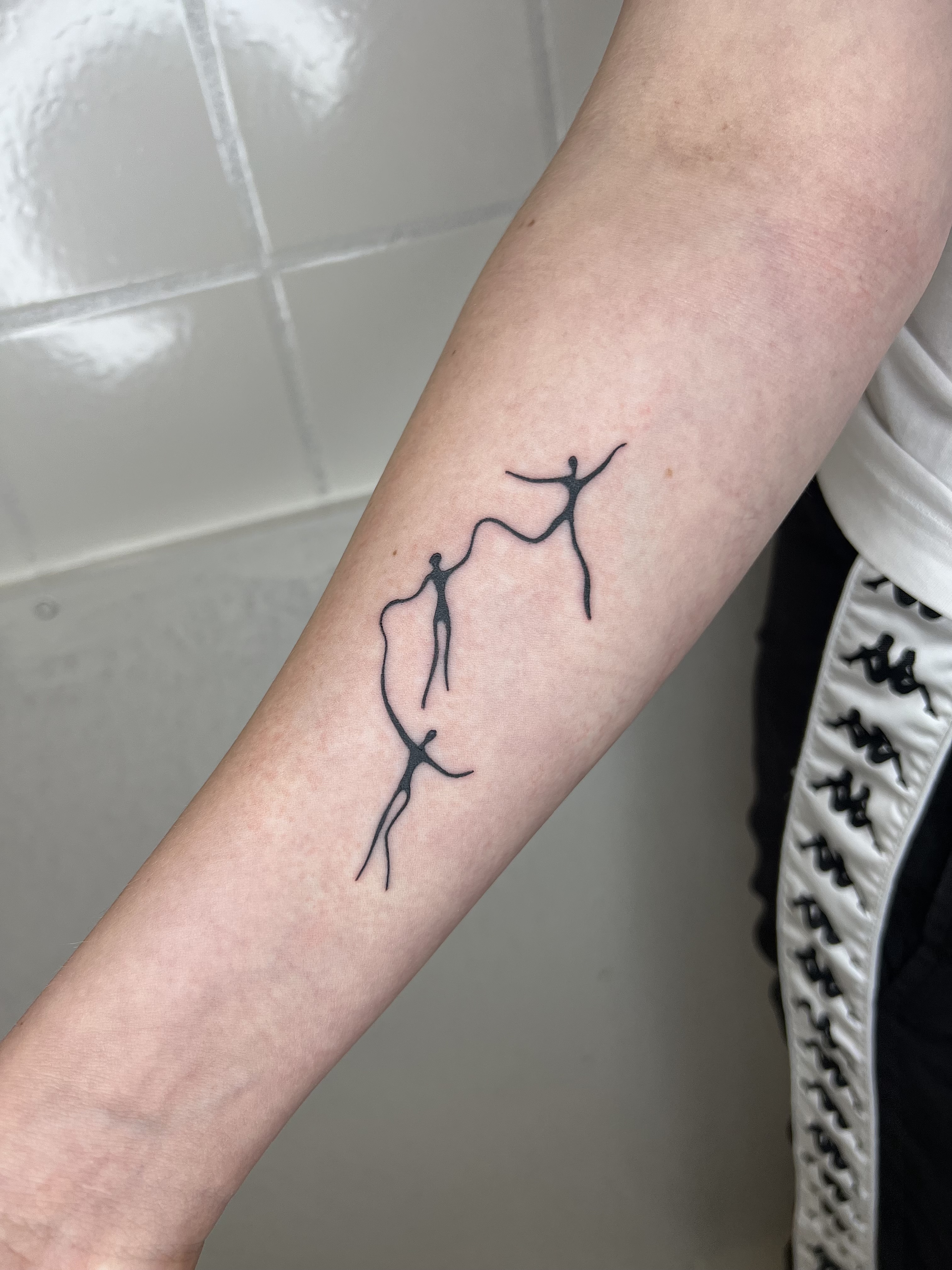 Abstract fine-line dancing figure tattoo by Amelie Anders, Copenhagen